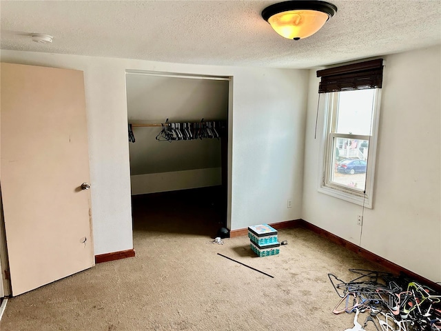 unfurnished bedroom featuring carpet, a textured ceiling, and a closet