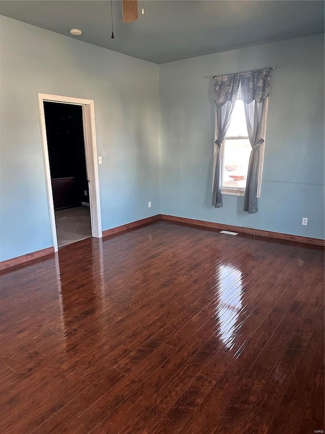 spare room with a ceiling fan, baseboards, and wood-type flooring