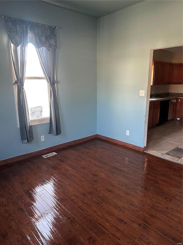 spare room with visible vents, baseboards, and hardwood / wood-style floors