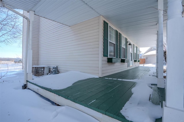 snow covered property with central AC unit