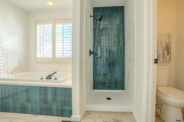 bathroom with shower with separate bathtub, hardwood / wood-style flooring, and toilet