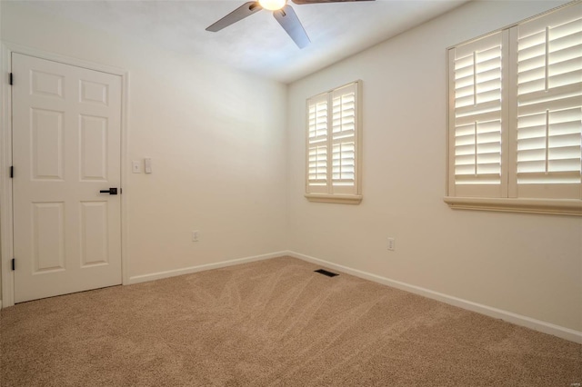 carpeted spare room featuring ceiling fan