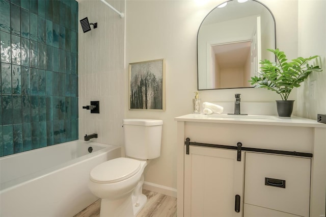 full bathroom featuring toilet, vanity, wood-type flooring, and tiled shower / bath