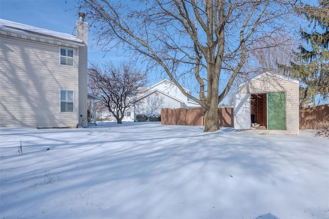 yard layered in snow with a storage unit