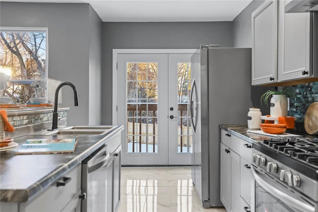 kitchen featuring sink, white cabinetry, appliances with stainless steel finishes, plenty of natural light, and french doors