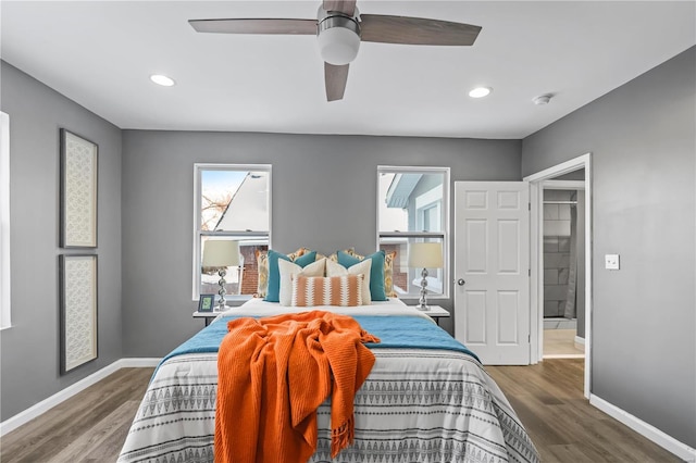 bedroom featuring ceiling fan, hardwood / wood-style floors, and multiple windows