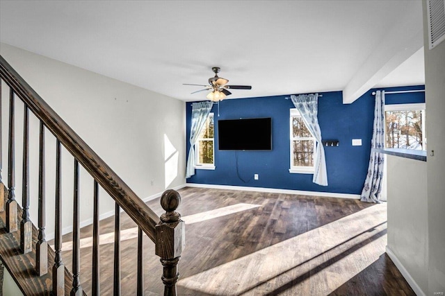 stairway featuring hardwood / wood-style flooring, beam ceiling, and ceiling fan