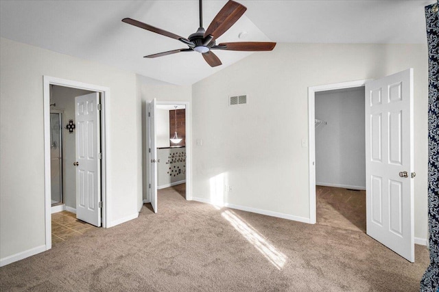 unfurnished bedroom featuring a spacious closet, lofted ceiling, light carpet, ceiling fan, and a closet