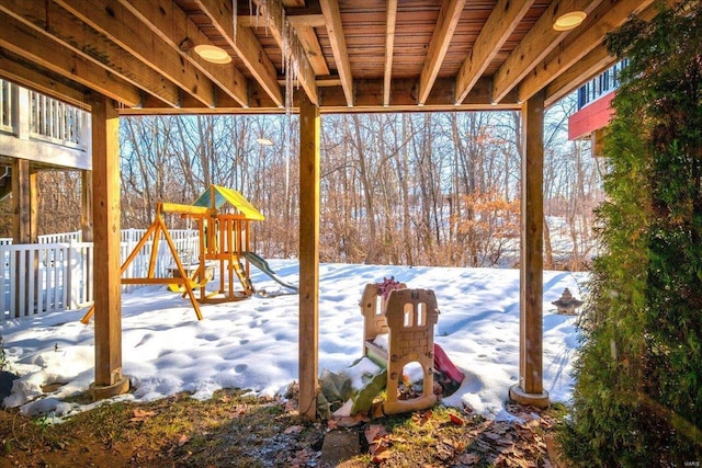 snow covered patio featuring a playground