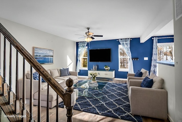 living room featuring baseboards, stairs, ceiling fan, and wood finished floors