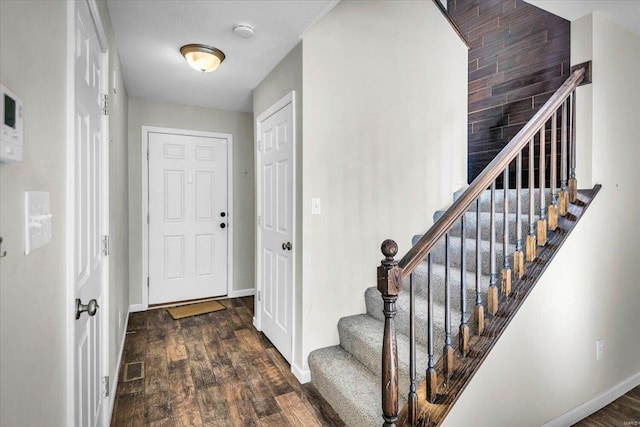 entrance foyer with stairs, wood finished floors, and baseboards