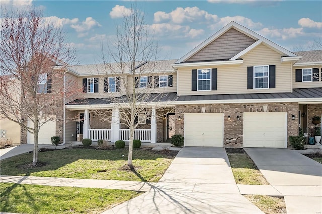 multi unit property featuring driveway, covered porch, a front lawn, a garage, and brick siding