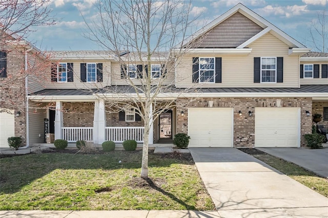 townhome / multi-family property featuring a porch, concrete driveway, a front yard, a garage, and brick siding