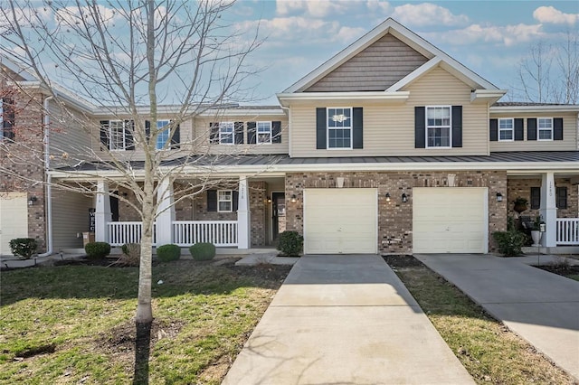 townhome / multi-family property featuring a garage, a front lawn, a porch, and driveway