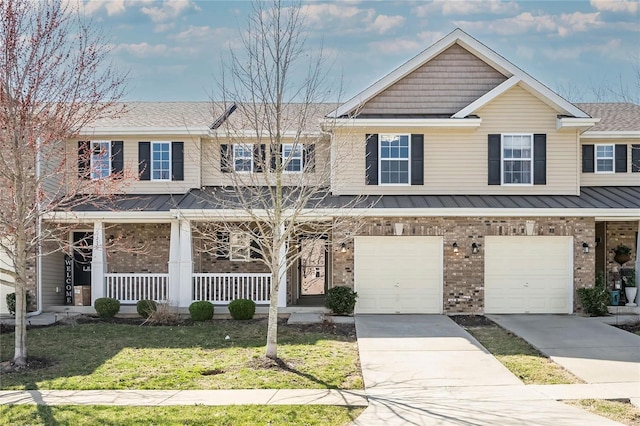 multi unit property featuring a porch, a front yard, driveway, and a garage