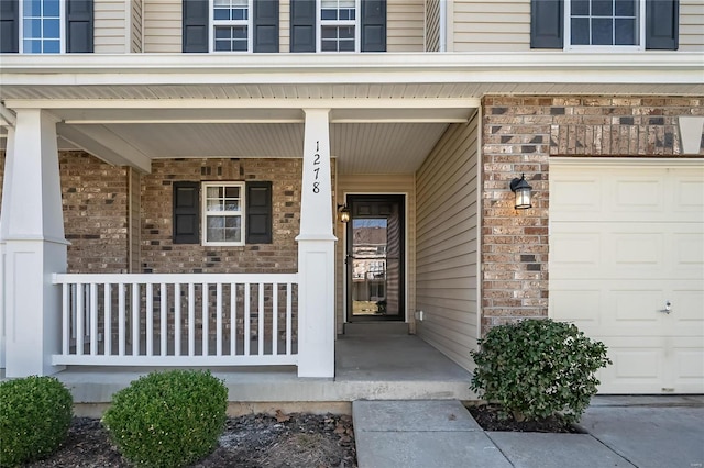 property entrance with a porch and brick siding