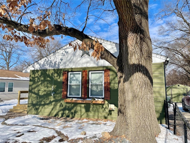 snow covered property featuring an outdoor structure