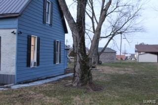 view of side of home with a yard