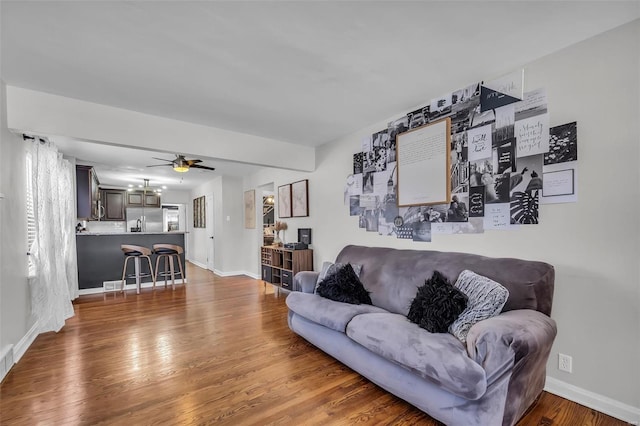 living room featuring ceiling fan and dark hardwood / wood-style floors