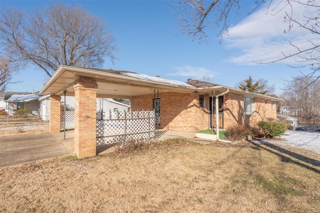 ranch-style house featuring a front lawn and a carport