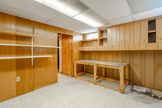 interior space with wooden walls and a drop ceiling