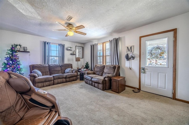 carpeted living room featuring ceiling fan, plenty of natural light, and a textured ceiling