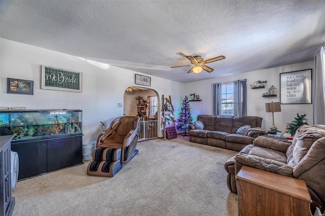 living room with ceiling fan, carpet floors, and a textured ceiling