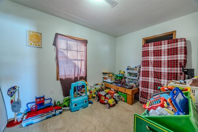 playroom with carpet and a textured ceiling