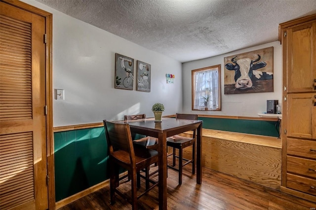 dining area with hardwood / wood-style floors and a textured ceiling