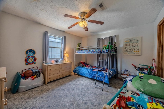 carpeted bedroom with ceiling fan and a textured ceiling