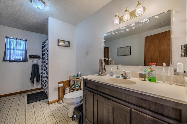 bathroom with vanity, tile patterned floors, a textured ceiling, and toilet