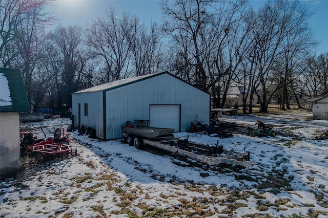 snow covered structure featuring a garage