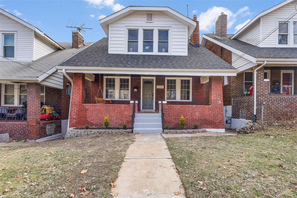 bungalow-style home with covered porch and a front lawn