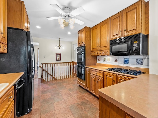 kitchen with hanging light fixtures, decorative backsplash, ceiling fan with notable chandelier, and black appliances