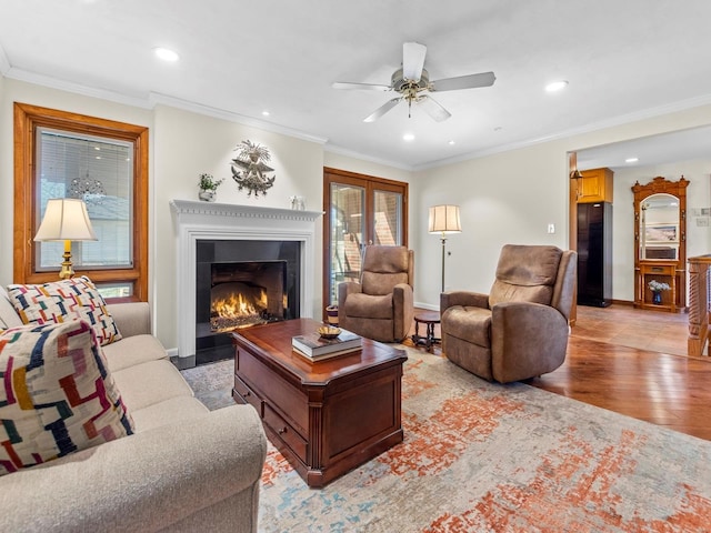 living room with french doors, crown molding, ceiling fan, and light hardwood / wood-style flooring