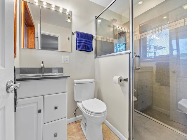 bathroom featuring vanity, a shower with shower door, tile patterned floors, and toilet