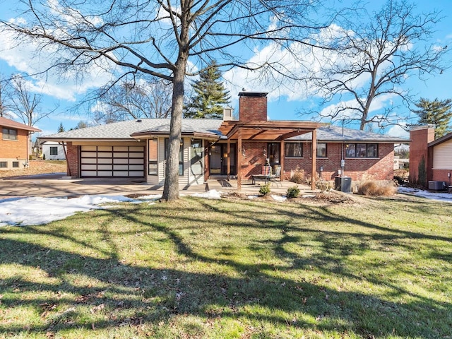 view of front of house with cooling unit, a garage, and a front lawn