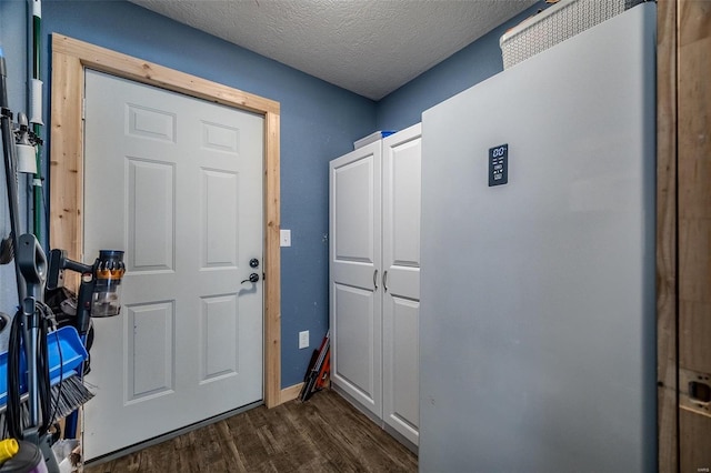 doorway to outside featuring a textured ceiling and dark hardwood / wood-style floors