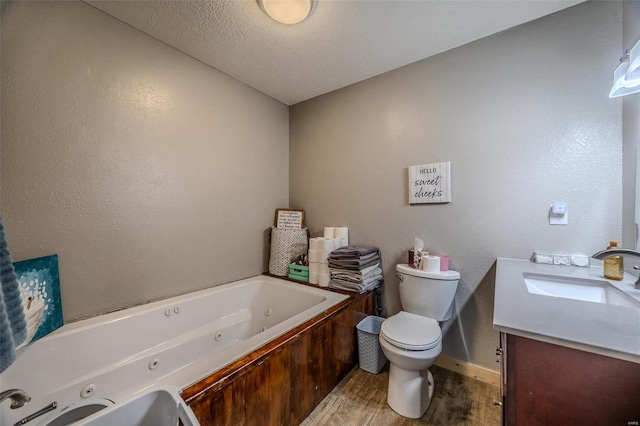 bathroom with toilet, a textured ceiling, a bathtub, hardwood / wood-style floors, and vanity