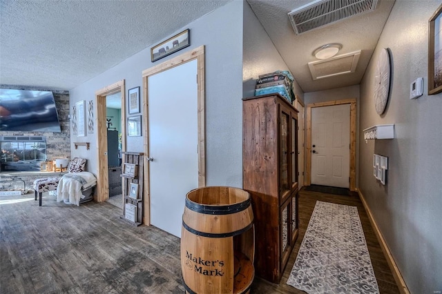 hallway with a textured ceiling and dark wood-type flooring