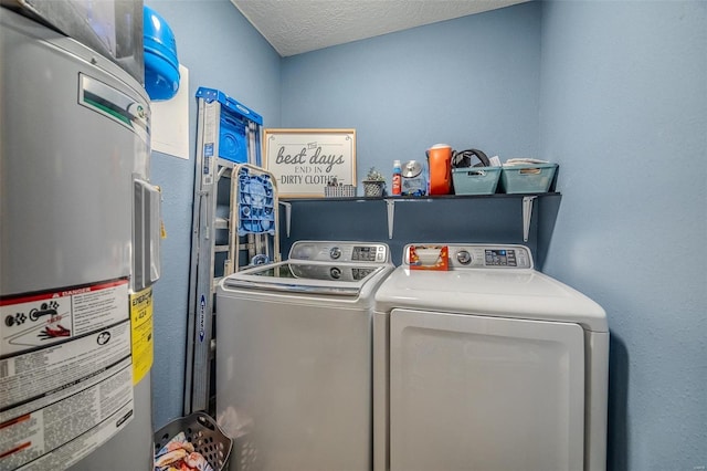 laundry room with a textured ceiling, separate washer and dryer, and water heater