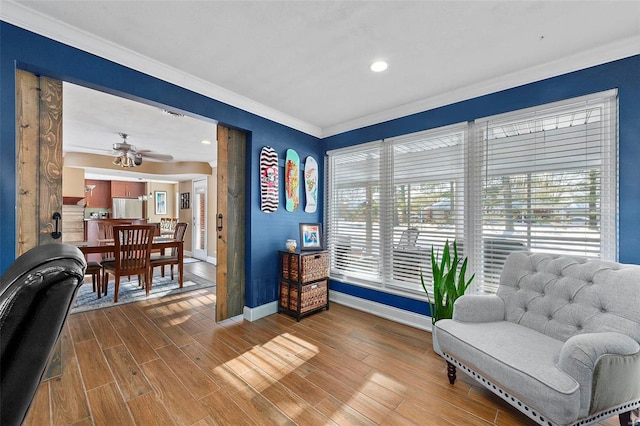 sitting room featuring ceiling fan and crown molding