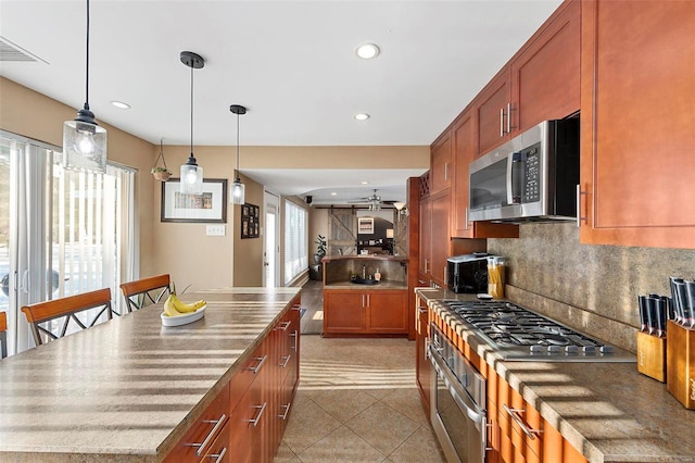 kitchen with decorative light fixtures, stainless steel appliances, backsplash, tile patterned floors, and ceiling fan