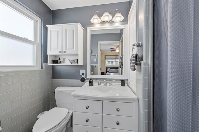 bathroom with tile walls, a shower with shower curtain, vanity, and plenty of natural light