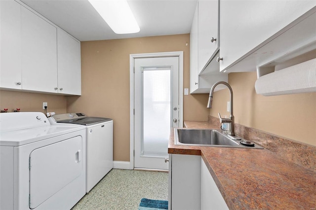 washroom with washer and dryer, cabinets, and sink