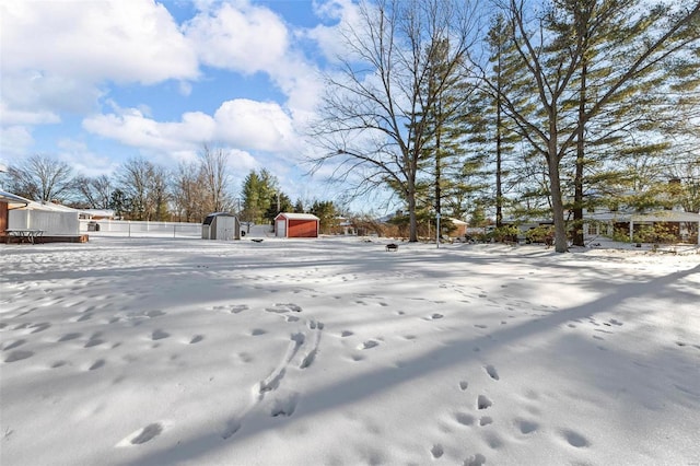 yard covered in snow featuring a storage unit