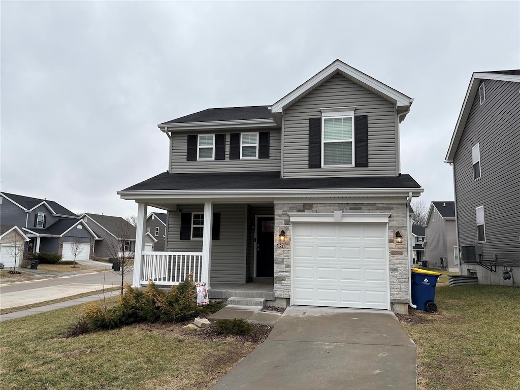 view of front of house featuring a garage, a front lawn, and a porch