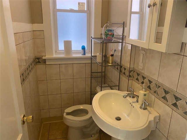 bathroom featuring sink, tile patterned flooring, tile walls, and toilet