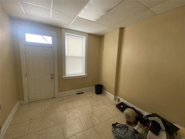 tiled entrance foyer featuring a paneled ceiling