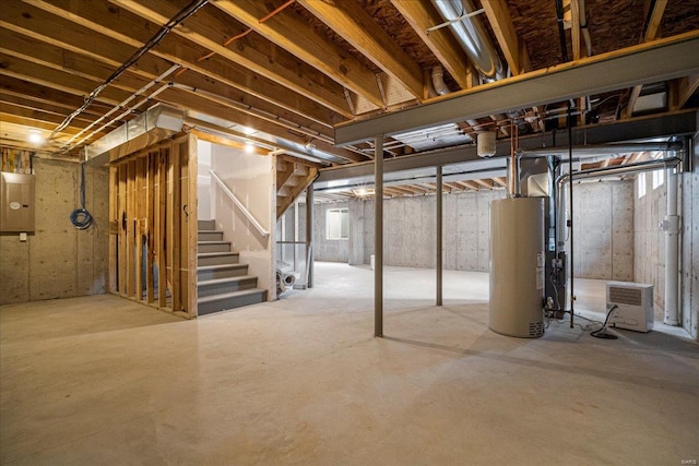 basement with gas water heater, electric panel, and stairs